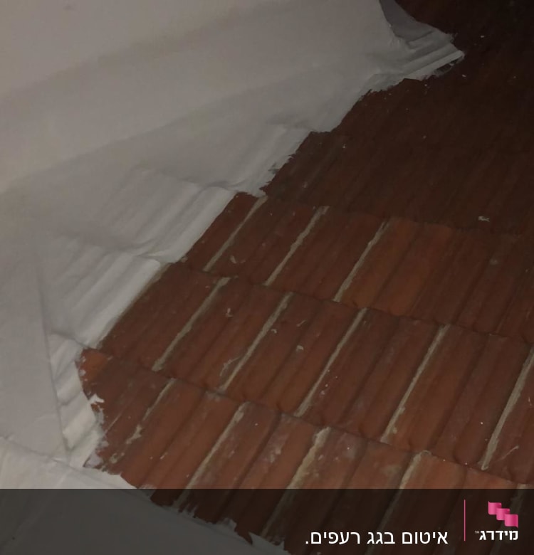 איטום גג עם חומר לבן על רעפים חומים